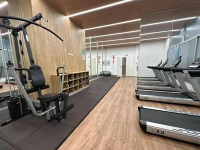 a gym with treadmills and ellipticals in a room at Urbana Perú Tempo in Lima