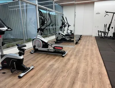 a gym with several treadmills and exercise bikes at Urbana Perú Tempo in Lima