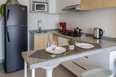 a kitchen with a counter with two plates and a refrigerator at Urbana Perú Tempo in Lima