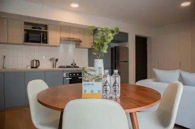 a kitchen with a wooden table with chairs and a vase at Fanning Apartments by Wynwood House in Lima