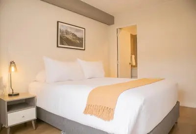 a bedroom with a large white bed and a night stand at Fanning Apartments by Wynwood House in Lima