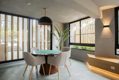 a dining room with a table and chairs and windows at Fanning Apartments by Wynwood House in Lima
