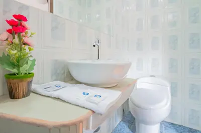 a white bathroom with a sink and a toilet at Inkary Hotel Machupicchu in Machu Picchu