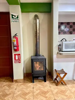 a fireplace in a kitchen with a stove at TORIBIANS Hotel in Chinchero