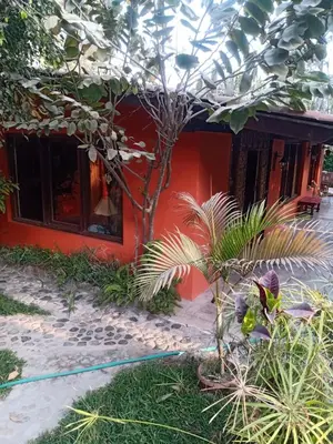 a red house with a hose in front of it at Rustic House, Pool, Grill, Game Area, Campfire Area in Cieneguilla