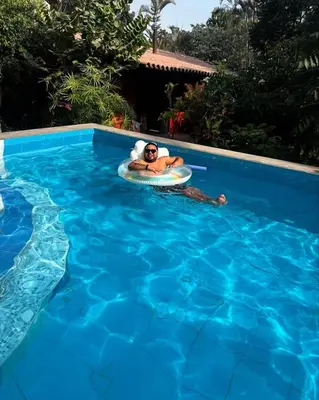 a woman laying on a raft in a swimming pool at Rustic House, Pool, Grill, Game Area, Campfire Area in Cieneguilla