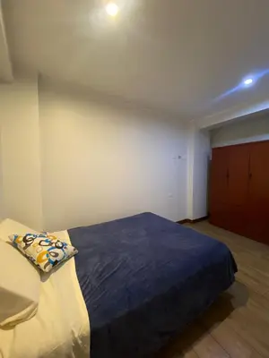 a bedroom with a bed with a blue blanket at Casa Olivo in Lima