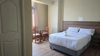 a bedroom with a bed and a table and chairs at MOON Edificio in San Vicente de Cañete