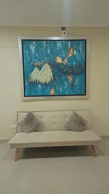 a painting hanging on a wall above a bench at MOON Edificio in San Vicente de Cañete