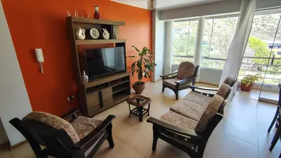 a living room with a tv and a couch and chairs at Departamento acogedor in Abancay