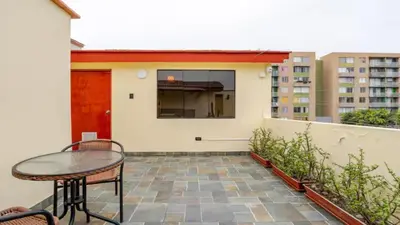 a patio with a table and chairs and a building at Loft equipado y acogedor con Terraza en Matellini in Lima
