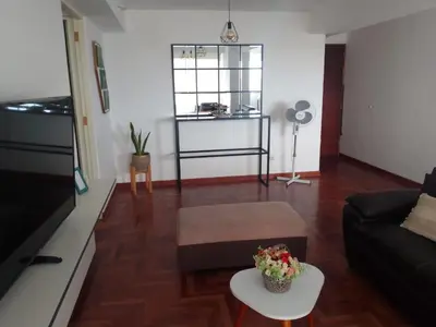 a living room with a couch and a table at Amplio, céntrico, buena vista in Lima