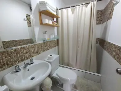 a bathroom with a white toilet and a sink at Amplio, céntrico, buena vista in Lima