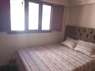 a bedroom with a bed with a bedspread and a window at El despertar del inka in Cusco