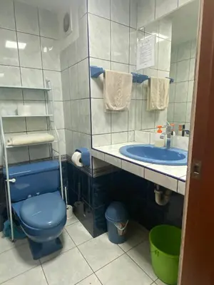 a bathroom with a blue toilet and a sink at Mini Supercentrico in Lima