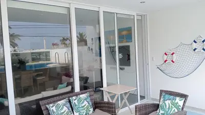 a living room with a balcony with a table and chairs at Aqua y Sol Private Pool Parking Air Conditioning in Playa de Santa María
