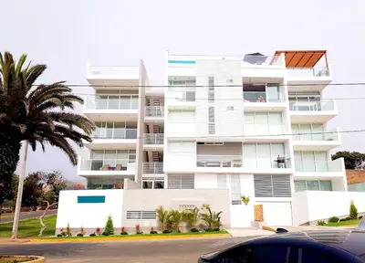 a white building with a palm tree in front of it at Aqua y Sol Private Pool Parking Air Conditioning in Playa de Santa María