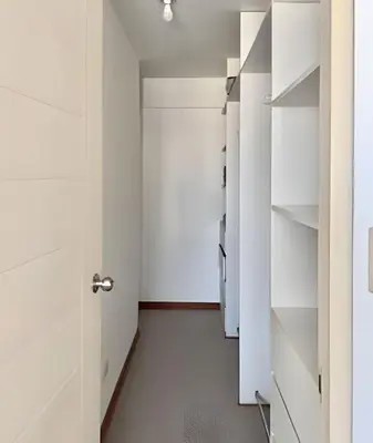 a walk in closet with white cabinets and a door at Big 3BR Apartment in the center of Miraflores in Lima