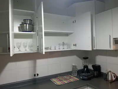 a kitchen counter with white cabinets and cups and appliances at Apartment in the center of Miraflores in Lima