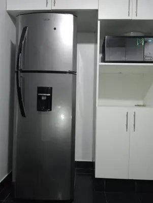 a stainless steel refrigerator in a kitchen with white cabinets at Apartment in the center of Miraflores in Lima