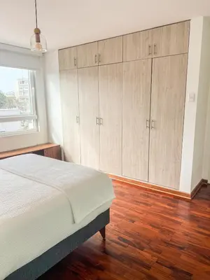 a bedroom with a bed with wooden floors and cabinets at LimaViva A in Lima