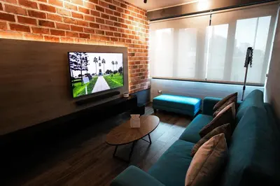 a living room with a blue couch and a tv at iStay 1bed 1Bathroom Urban Deluxe in Lima