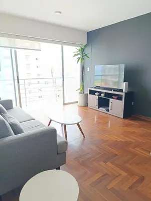 a living room with a couch and a flat screen tv at iStay 2D a 1 cuadra del Malecon in Lima