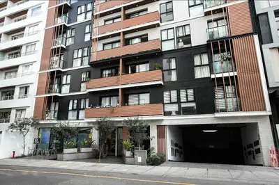 a large building with a parking garage in front of it at iStay Atractivo corazón de Miraflores 2 Camas 2 Baños in Lima