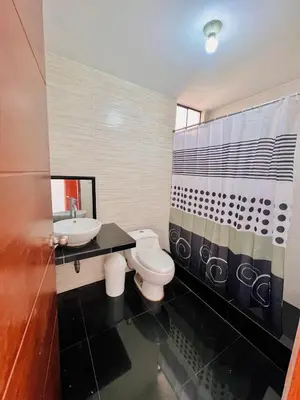 a bathroom with a toilet and a sink at Casa Cubo Deluxe in La Molina in Lima