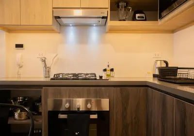 a kitchen with a stove top oven next to a counter at Palma Suites by Wynwood House in Lima