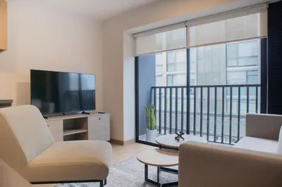 a living room with a television and a balcony at Palma Suites by Wynwood House in Lima