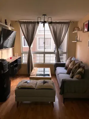 a living room with a couch and a table at Departamento Condominio Club Carabayllo in Carabayllo