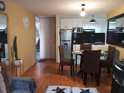 a kitchen and living room with a table and chairs at Departamento Condominio Club Carabayllo in Carabayllo