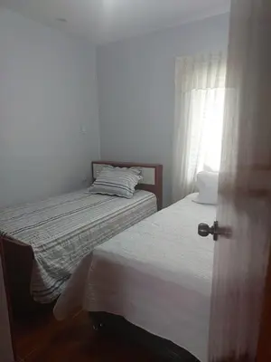 a small bedroom with two beds and a window at H&H home in Cusco
