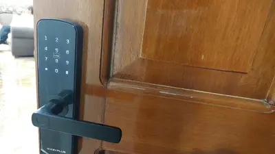 a remote control attached to a wooden door at H&H home in Cusco