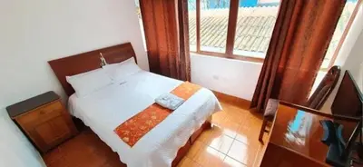 a small bedroom with a bed and a window at Hoteles Romero in Machu Picchu