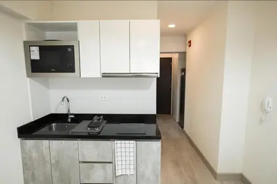 a kitchen with a sink and a microwave at iStay Encantador Loft Piscina BBQ Gym Bicicleta in Lima
