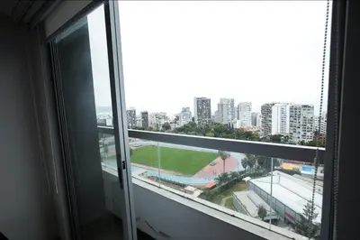 an open window with a view of a city at iStay Encantador Loft Piscina BBQ Gym Bicicleta in Lima