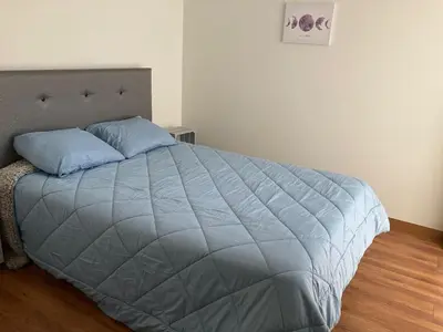 a bedroom with a large bed with blue pillows at iStay Santuario Linsidro Cerca Hospitales Gym in Lima