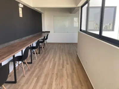 a row of desks in a room with chairs at iStay Santuario Linsidro Cerca Hospitales Gym in Lima