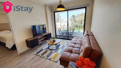 a living room with a couch and a large window at iStay Nuevo 2D 2B Balcón in Lima