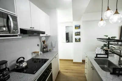 a kitchen with white cabinets and a stove top oven at Mezanine Deluxe Miraflores in Lima