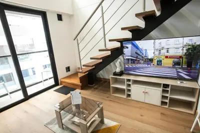 a living room with a tv and a staircase at Mezanine Deluxe Miraflores in Lima