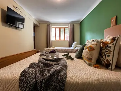 a large bed in a room with green walls at Casa Paqocha Garden - Ollantaytambo - Hot Water - Wifi - Cocina Compartida in Ollantaytambo