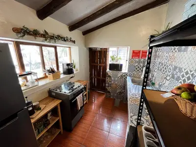 a kitchen with a refrigerator and a stove top oven at Casa Paqocha Garden - Ollantaytambo - Hot Water - Wifi - Cocina Compartida in Ollantaytambo