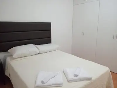 a white bed with two white towels on it at Super departamento en el centro de Miraflores in Lima