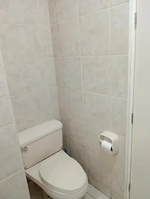 a bathroom with a toilet and a toilet paper dispenser at Super departamento en el centro de Miraflores in Lima