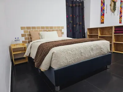 a bedroom with a large bed with a brown blanket at Chakanas House in Cusco