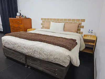 a bedroom with a large bed and a wooden dresser at Chakanas House in Cusco