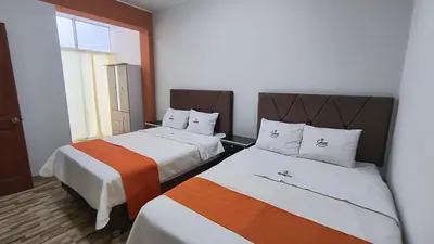 two beds in a small room with a window at Departamentos Sumaq Plaza - Libertad in Ayacucho